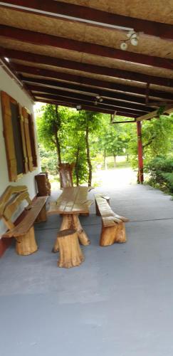a group of wooden benches sitting under a pavilion at Dobó Tanya in Röszke