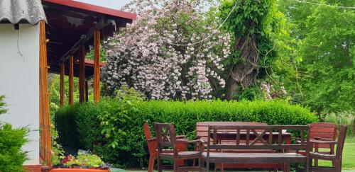 a picnic table and chairs in a garden with flowers at Dobó Tanya in Röszke