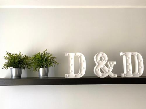 a shelf with a drug sign and two plants at Appartamento D & D in Niscemi
