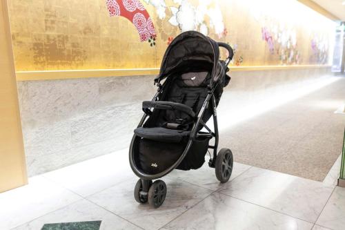 a black baby stroller sitting in a hallway at Dotonbori Hotel in Osaka