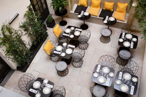 einen Blick über ein Restaurant mit Tischen und Stühlen in der Unterkunft Le Damantin Hôtel & Spa in Paris