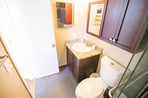 een kleine badkamer met een toilet en een wastafel bij The Victor Apartments By Lowkl in Fort Lauderdale