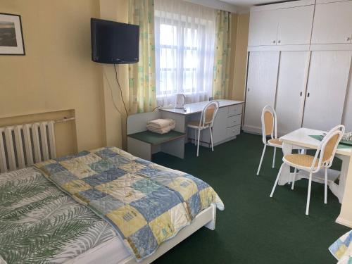a bedroom with a bed and a table and a desk at Samana in Tytuvėnai