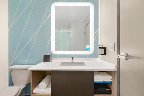 a bathroom with a sink and a mirror at avid hotels - Boston Logan Airport - Revere, an IHG Hotel in Revere