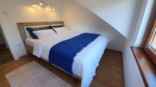 1 dormitorio con 1 cama grande con sábanas azules y blancas en Bella Ciao, en Vrnjačka Banja