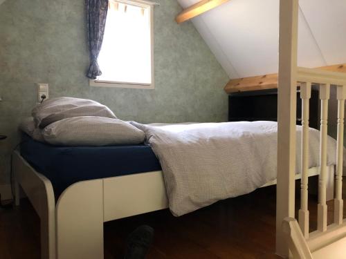 a small bedroom with a bed with a window at Cozy Cottage in Utrecht