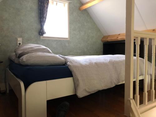 Dormitorio pequeño con cama y ventana en Cozy Cottage, en Utrecht
