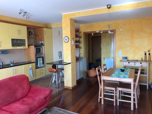 a living room and kitchen with a red couch and a table at Lavra Sea & Sun Beach Apartment (up to 4 guests) in Lavra