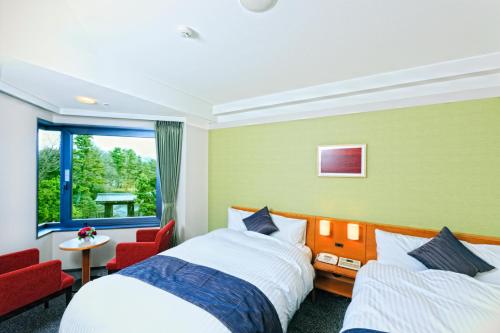 a hotel room with two beds and a window at Kyoto Garden Palace in Kyoto