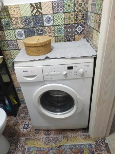 a washing machine in a bathroom with a tile wall at Апартаменти Світлий Ранок та Затишний Вечір in Rivne