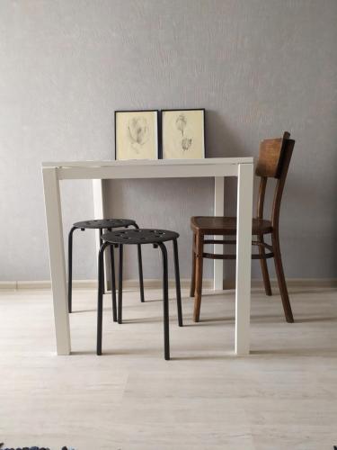 a white table with two chairs and a table with two pictures at Апартаменти Світлий Ранок та Затишний Вечір in Rivne