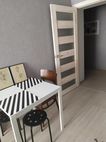 a room with a table and two chairs and a ladder at Апартаменти Світлий Ранок та Затишний Вечір in Rivne