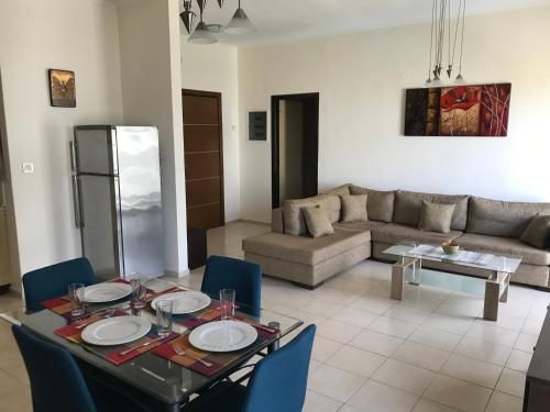 a living room with a table and chairs and a couch at Apartment on the Beach with View in Rethymno