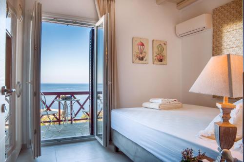 a bedroom with a bed and a view of the ocean at Eleni's Guesthouse in Apróvaton
