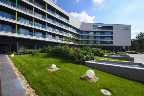 a building with a lawn in front of a building at Hunguest Hotel Sóstó in Nyíregyháza