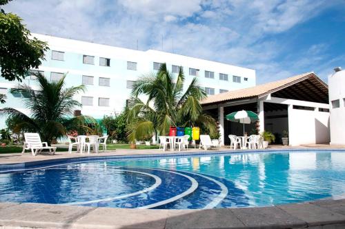 a swimming pool in front of a hotel at Delcas Hotel in Cuiabá