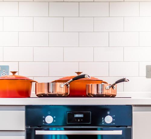 two pots sitting on top of a stove at Castle View Luxury 1 Bed Apartment in Edinburgh