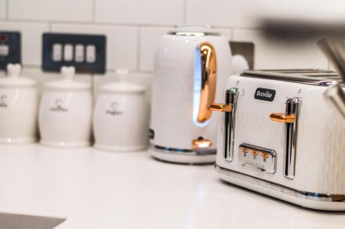 a row of toasters sitting on a kitchen counter at Castle View Luxury 1 Bed Apartment in Edinburgh