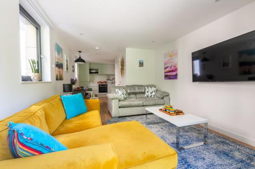 a living room with a yellow couch and a table at Castle View Luxury 1 Bed Apartment in Edinburgh