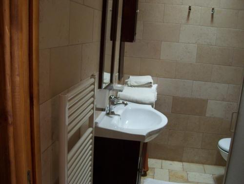 ein Bad mit einem Waschbecken, einem WC und Handtüchern in der Unterkunft Agriturismo Locanda Ventura in Fasano