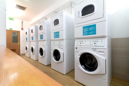 a row of washing machines and dryers in a laundry room at Staybridge Suites Guadalajara Expo by IHG in Guadalajara