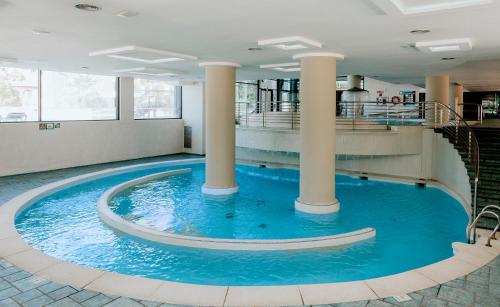 a large swimming pool in a building with columns at Hotel Deloix 4* Sup in Benidorm
