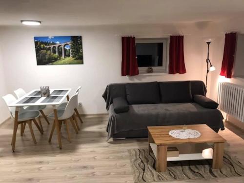 a living room with a black couch and a table at Apartmán Jedlička in Telgárt