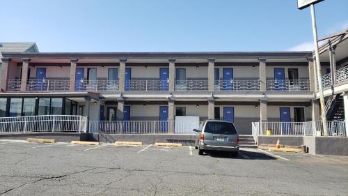 a car parked in a parking lot in front of a building at Rest Inn - Elizabeth in Elizabeth