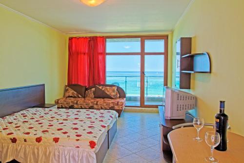 a bedroom with a bed and a couch and a window at Black Sea Paradise Hotel in Sozopol