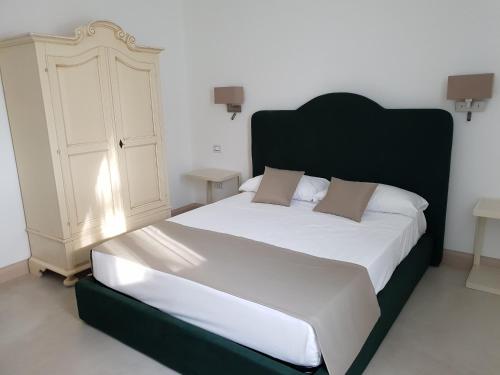 a bedroom with a large bed with a black headboard at Villa Natia in Mottola