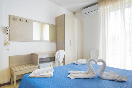 Un dormitorio con dos cisnes hechos para parecer corazones en Hotel Carillon, en Bellaria-Igea Marina