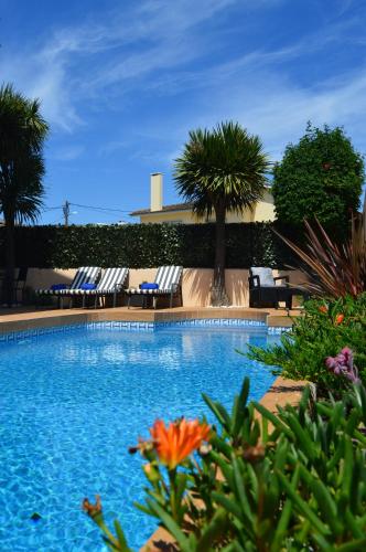 a swimming pool with lounge chairs and palm trees at Lourenço's House Deluxe Cascais in Cascais