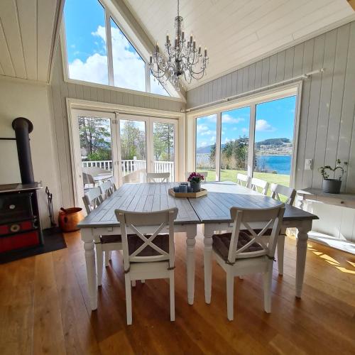 a dining room with a table and chairs and windows at Lysefjorden - Gøysa Gard in Forsand