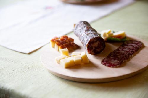 a plate of food with sausage and cheese on a table at Turistična Kmetija Zgornji Zavratnik in Luče