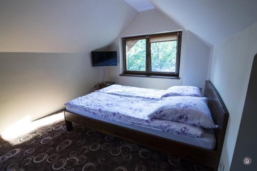 Un dormitorio pequeño con una cama con ventana. en Siedlisko Na Fali, en Krynica Morska