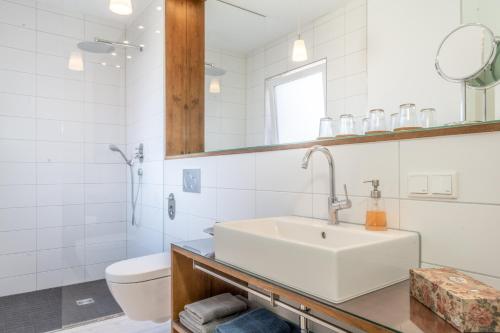 biała łazienka z umywalką i toaletą w obiekcie Ferienwohnung Ludwigstrasse w Norymberdze