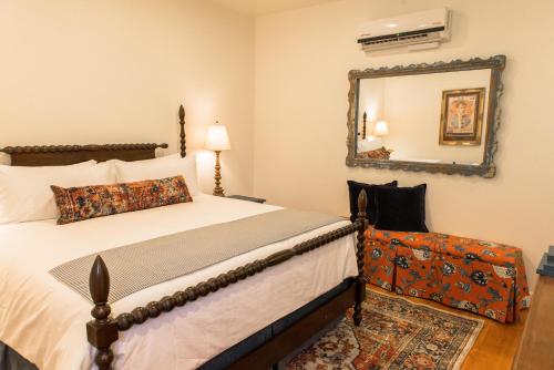 a bedroom with a bed and a mirror at Armory Park Inn in Tucson