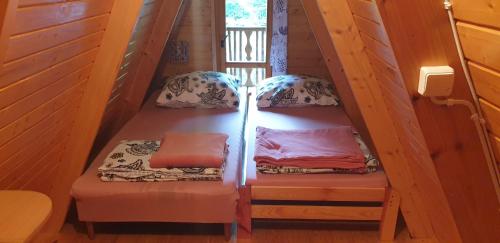 Una escalera con 2 camas en una casa en Domki letniskowe Pod Lasem en Koziniec