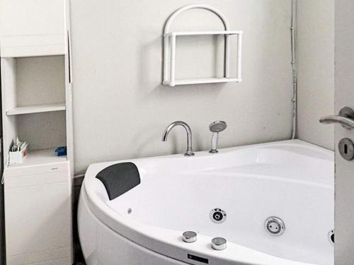 uma banheira branca na casa de banho com um lavatório em 6 person holiday home in G rlev em Gørlev