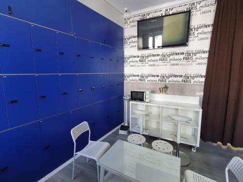 a dining room with blue cabinets and a table and chairs at CH Plaza D'Ort Rooms Madrid in Madrid