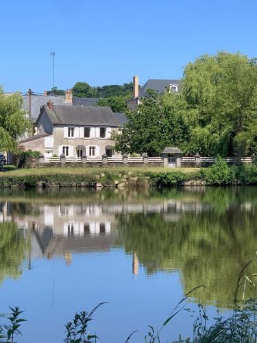 una casa sentada junto a un cuerpo de agua en River Cottage 2 nuits minimums par réservation, en Daon