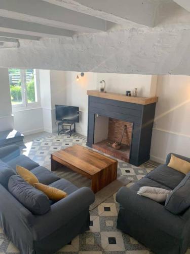 ein Wohnzimmer mit einem Sofa und einem Kamin in der Unterkunft River Cottage 2 nuits minimums par réservation in Daon