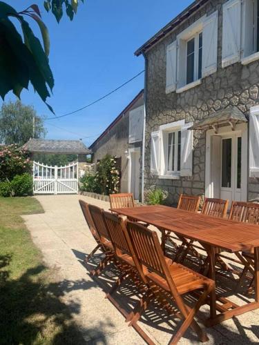 una mesa de madera y sillas frente a una casa en River Cottage 2 nuits minimums par réservation, en Daon