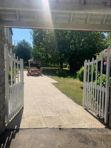 a white fence in a yard with a picnic table at River Cottage 2 nuits minimums par réservation in Daon