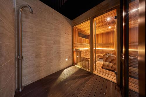a walk in shower in a room with wood flooring at Aparthotel Svatý Vavřinec in Pec pod Sněžkou