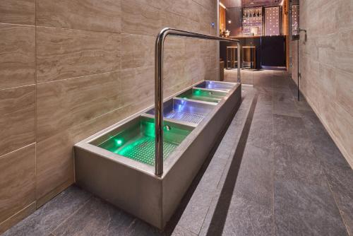 a bathroom with a tub with a green water at Aparthotel Svatý Vavřinec in Pec pod Sněžkou