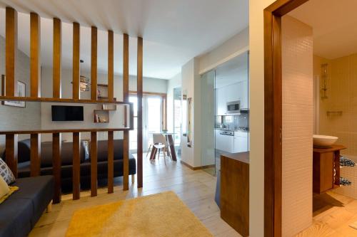 a living room with a couch and a kitchen at Flat Casino Beach Figueira da Foz - Moderno & Ótima Localização! in Figueira da Foz