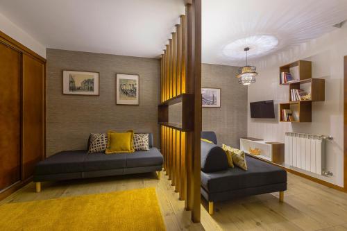 a living room with two couches and a staircase at Flat Casino Beach Figueira da Foz - Moderno & Ótima Localização! in Figueira da Foz