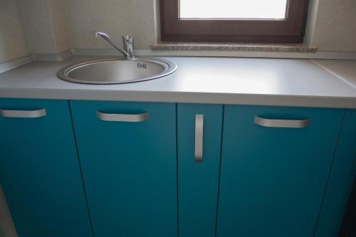 a bathroom with a sink and a blue cabinet at Palas Studios in Iaşi