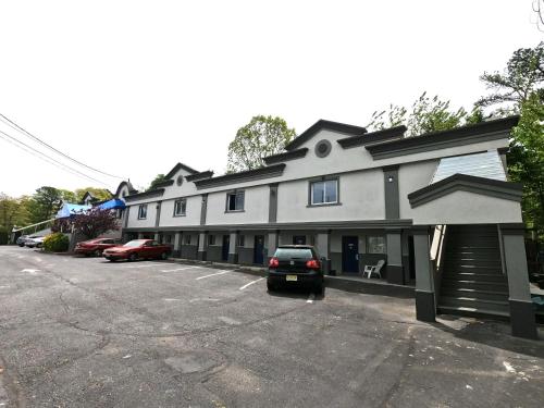a building with a car parked in a parking lot at Motel 6-Toms River, NJ in Toms River